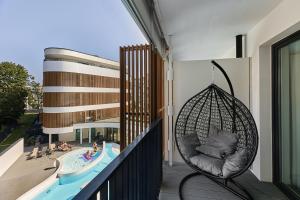 a swing on a balcony with a swimming pool at Baltic Waves Resort & Wellness I Where the Baltic Meets Luxury in Międzyzdroje