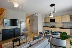 a living room with a couch and a table and chairs at Resort Baltic Waves Apartments - Basen, Sauna in Międzyzdroje +92 photos