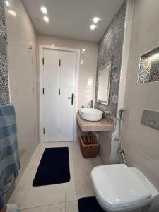 a bathroom with a white toilet and a sink at Charming apartment In Heliopolis in Cairo +64 photos