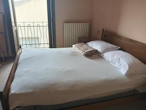 a bedroom with a bed with white sheets and pillows at La casa di Ninetta in Barisciano