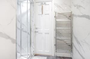 MarkinchにあるThe Wee Haig - 1 Bedroom Condoの白いドアとガラスの棚付きのバスルーム +7枚の写真