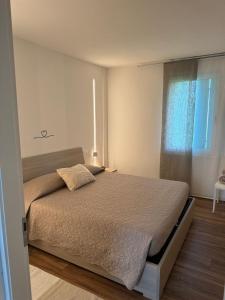 una camera da letto con un letto grande con una finestra di Casa S. Caterina a Piaia