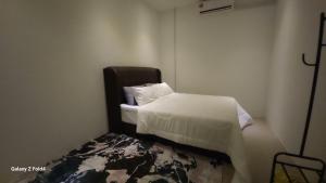 a bedroom with a bed with white sheets and pillows at Homestay Kubang Kerian by The Stay Homestay 04 in Kampong Chabang Pasir