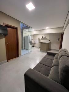a living room with a couch and a kitchen at Zaffir Apartamento in Cuiabá