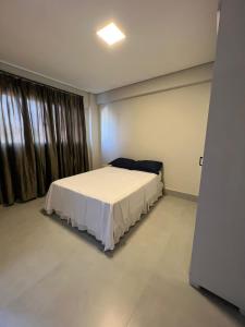 a bedroom with a bed in a room with a window at Zaffir Apartamento in Cuiabá