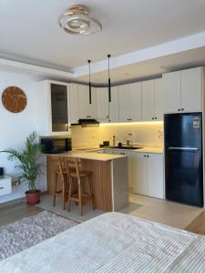 a kitchen with white cabinets and a black refrigerator at Unique Sunset Studio in Sharm El Sheikh