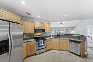 a kitchen with wooden cabinets and stainless steel appliances at Wander by the Waves Pet Friendly in Palm Coast