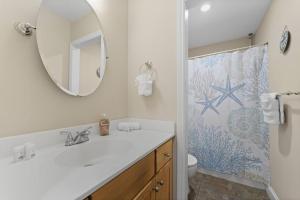 a bathroom with a sink and a mirror at Wander by the Waves Pet Friendly in Palm Coast +43 photos