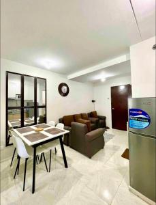 una cucina e un soggiorno con un tavolo e un divano di Condo Unit in Banilad Mandaue Cebu - 1 to 3 pax booking granted a 1 bedroom unit of your choice and a minimum of 4 guests for a 2 bedroom unit a Mandaue Altre 9 foto