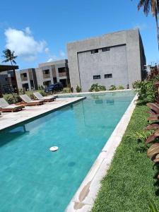 a swimming pool with a frisbee in front of a building at Villas Patacho G 102 - Milagres in Pôrto de Pedras