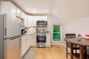 a kitchen with white appliances and a wooden table at Walkable Allentown Downtown Gem with King Bed in Buffalo