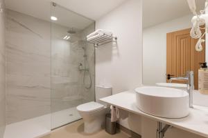 a white bathroom with a sink and a shower at Hotel Margarida Da Praça in Viana do Castelo +49 photos