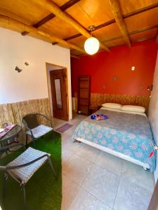 een slaapkamer met een bed, een tafel en een stoel bij Surf House Chicama in Puerto Chicama