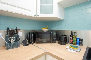 a kitchen with a counter top with a microwave at Ty Loan I Hyper centre & Balcon in Crozon
