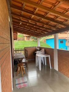 d'une terrasse avec une table et des chaises sur un mur en briques. dans l'établissement Casa do Rafael, à Conceição da Ibitipoca