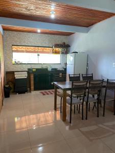 une cuisine et une salle à manger avec une table et des chaises dans l'établissement Casa do Rafael, à Conceição da Ibitipoca