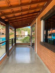 un patio vide avec un mur de briques et des fenêtres dans l'établissement Casa do Rafael, à Conceição da Ibitipoca