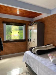une chambre avec un grand lit et une fenêtre dans l'établissement Casa do Rafael, à Conceição da Ibitipoca 14 autres photos