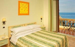 Postel nebo postele na pokoji v ubytování Jonic Hotel Mazzarò