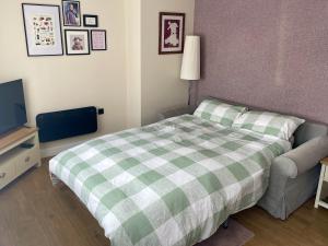 Schlafzimmer mit einem grünen und weißen Bett und einem TV in der Unterkunft Blackberry Cottage in Cardiff + 15 Fotos