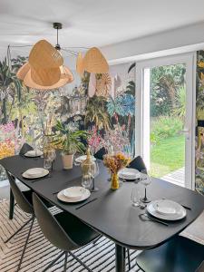 a black dining room table with black chairs at Villa calme avec piscine et spa à Mérignac Proche hôpital tram et parc d activité in Mérignac +27 photos