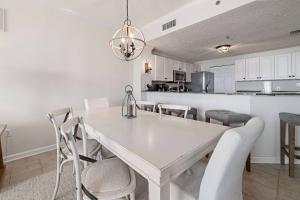 a kitchen and dining room with a white table and chairs at Beach Club A-706 in Gulf Highlands