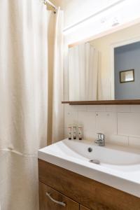 een badkamer met een witte wastafel en een spiegel bij Maison de village panoramique in Châteauneuf-du-Pape