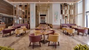 a restaurant with tables and chairs in a room at InterContinental Fujairah Resort by IHG in Al Aqah