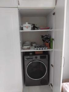 a kitchen with a stove and a washing machine at Lili's Flat in Angisa