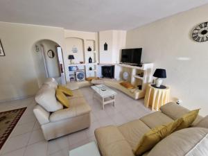 a living room with two couches and a tv at LeComer in Carvoeiro