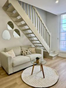 a living room with a couch and a staircase at Golden Duplex Chic - Centre-Clim-Parking in Narbonne