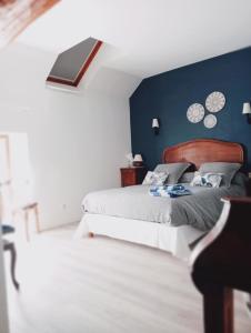 a bedroom with a bed and a blue wall at La Ferme de Plénoise Chambre & Table d'hôtes in Fricambault