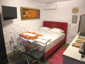 a bedroom with a bed and a table and a desk at Anastasia Luxury Villas in Gavrio
