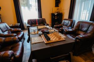 a living room with a chessboard on a table and leather chairs at IRIS BOUTIQUE - 4Star Bed & Breakfast Residence in Vatra Dornei in Vatra Dornei