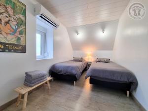 a room with two beds and a bench in it at Maison avec grand jardin clos, baby-foot, barbecue, garage, Wi-Fi - Calme et confort en Flandre - FR-1-510-221 in Eecke