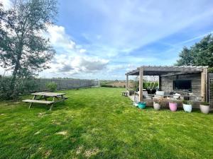 a picnic table and a picnic shelter in a yard at Maison avec grand jardin clos, baby-foot, barbecue, garage, Wi-Fi - Calme et confort en Flandre - FR-1-510-221 in Eecke