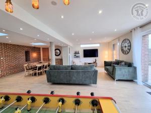 a living room with a ping pong table in the middle at Maison avec grand jardin clos, baby-foot, barbecue, garage, Wi-Fi - Calme et confort en Flandre - FR-1-510-221 in Eecke +28 photos