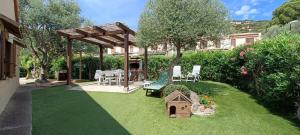 a garden with a table and a bench and a bird house at Casa Marcella in Costa Rei