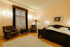 a bedroom with a bed and two chairs at IRIS BOUTIQUE - 4Star Bed & Breakfast Residence in Vatra Dornei in Vatra Dornei +38 photos