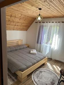 a bedroom with a bed and a wooden ceiling at Bujtina Kometa in Theth