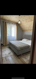 una camera con un grande letto e un soffitto in legno di Bujtina Kometa a Theth Altre 16 foto