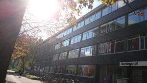 a building with a person walking in front of it at Hotel King's Court in Amsterdam