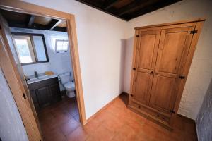 a bathroom with a toilet and a wooden cabinet at Club JM Lanzarote in Tabayesco