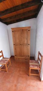 a room with two chairs and a wooden cabinet at Club JM Lanzarote in Tabayesco