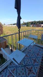 a patio with a table and chairs and an umbrella at Charmante appartement in Wilrijk in Antwerp