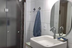 a white bathroom with a sink and a mirror at Apartamento vista mar Santos in Santos +11 photos