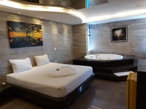 a bedroom with a bed and a bath tub at Motel Park Way in Brasilia