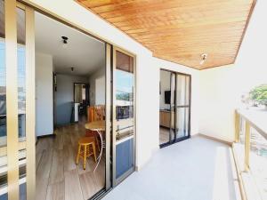 a balcony with glass doors and a table with chairs at Sobrado 30 m praia, quartos climatizados, 1 vaga, até 6 pessoas in Bombinhas