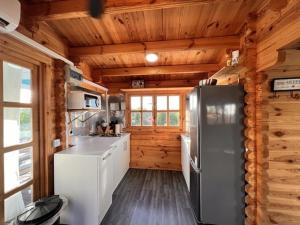 a kitchen in a log cabin with a refrigerator at Kalma experiencias turísticas in Cádiz