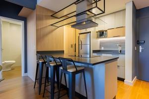 una cucina con isola e sgabelli da bar di Apto Super Moderno e Central a Florianópolis